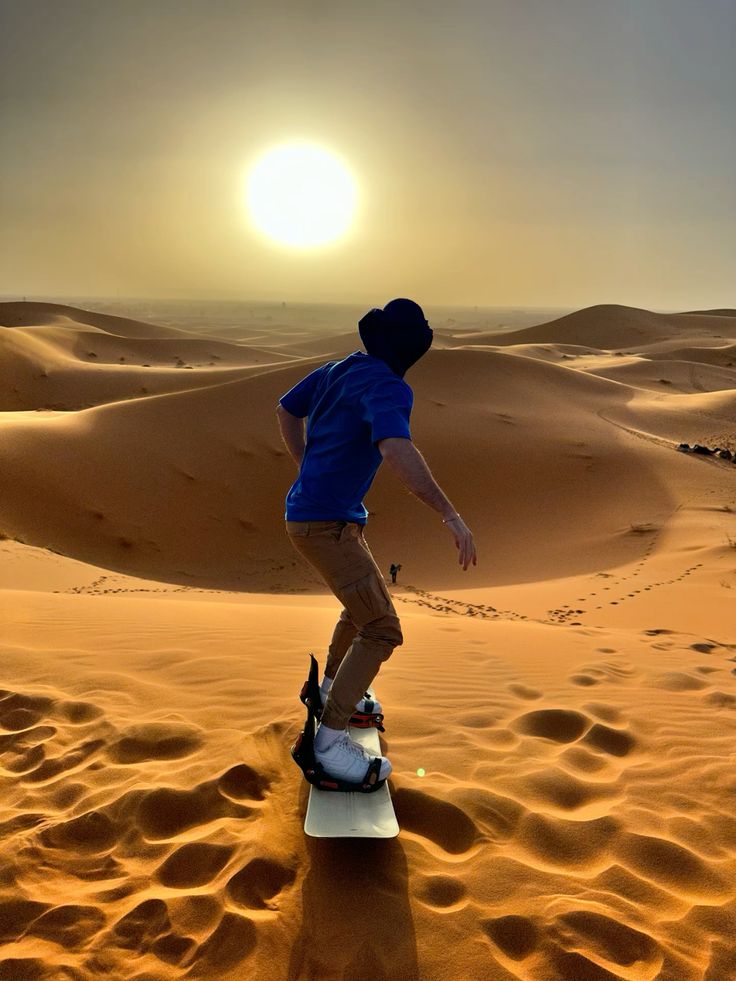Sandboarder carving down the face of a dune